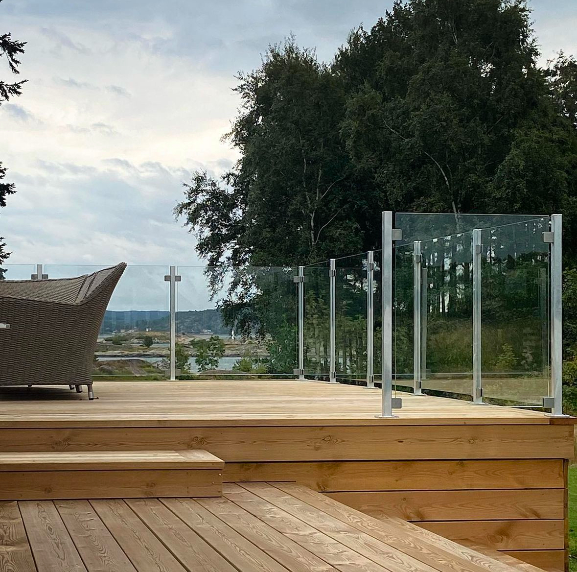 Glasräcke med rostfria stolpar på altan med skärgårdsutsikt