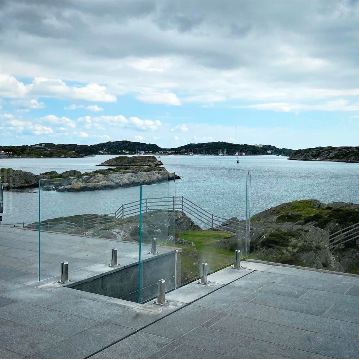 Glasräcke med beslag på terrass med havsutsikt